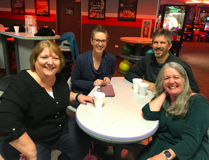 A small group of Peak team members at a table at the bowling alley