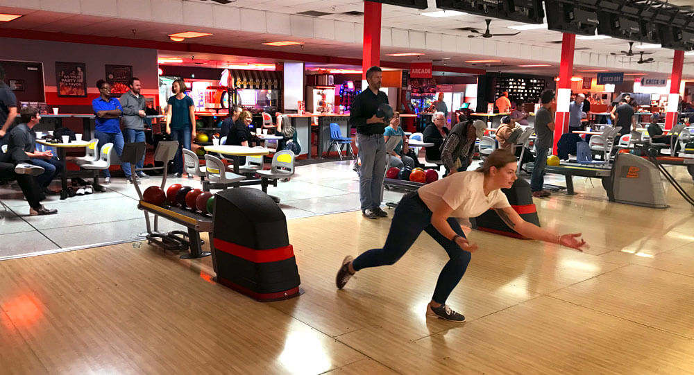 Peak team bowling balls down the lanes at a Peak bowling party