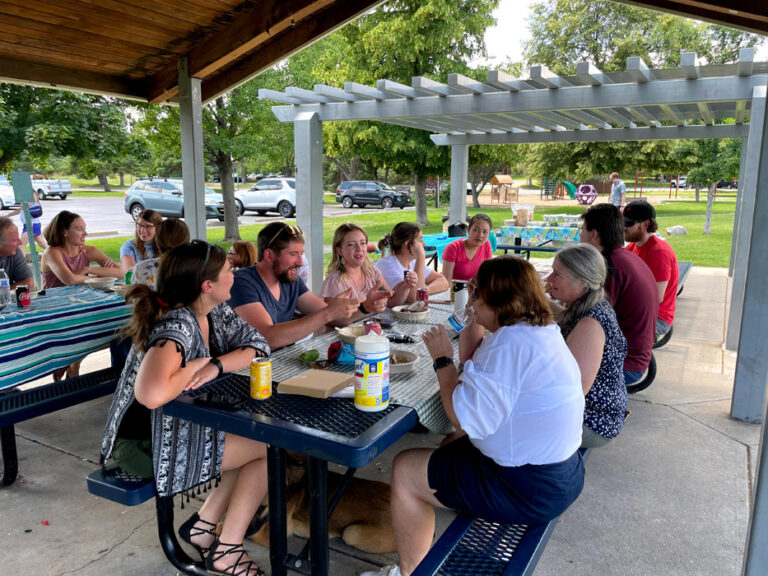 Peak team eating at picnic tables at the Peak picnic