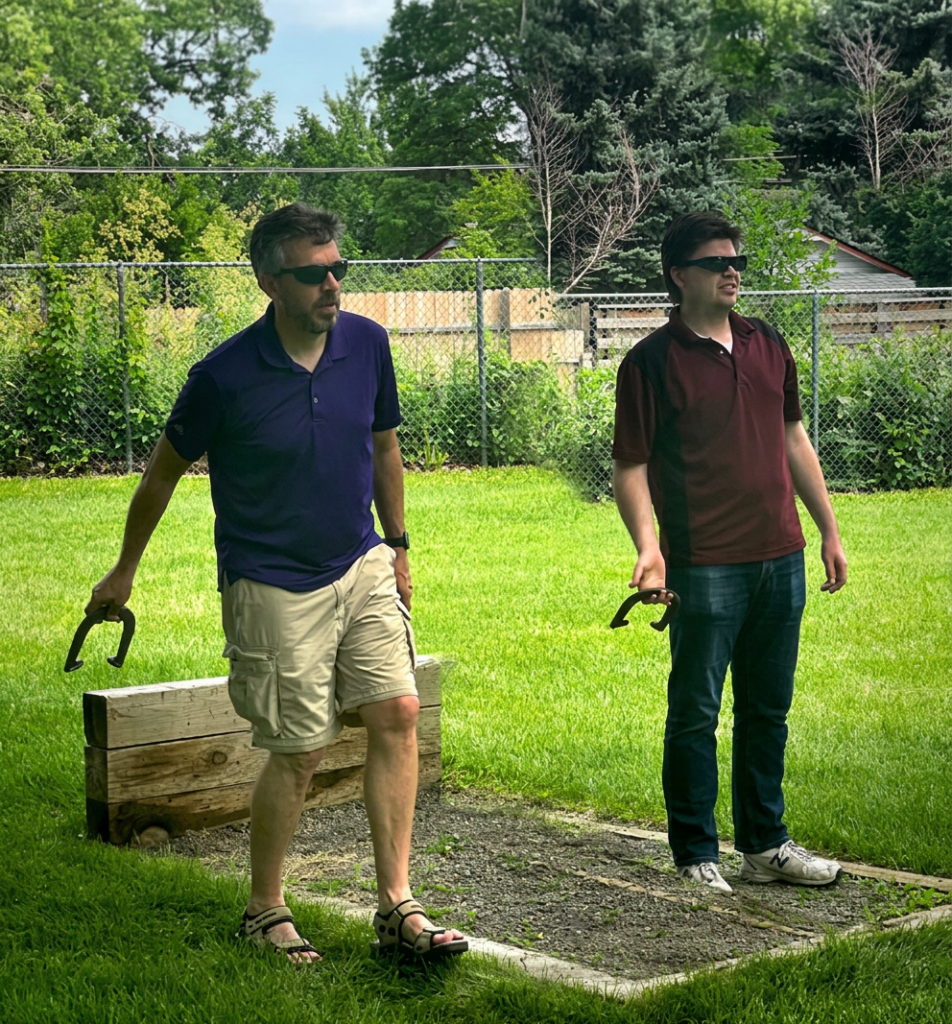 John Hart and Sean Wirth playing horse shoes at a Peak picnic